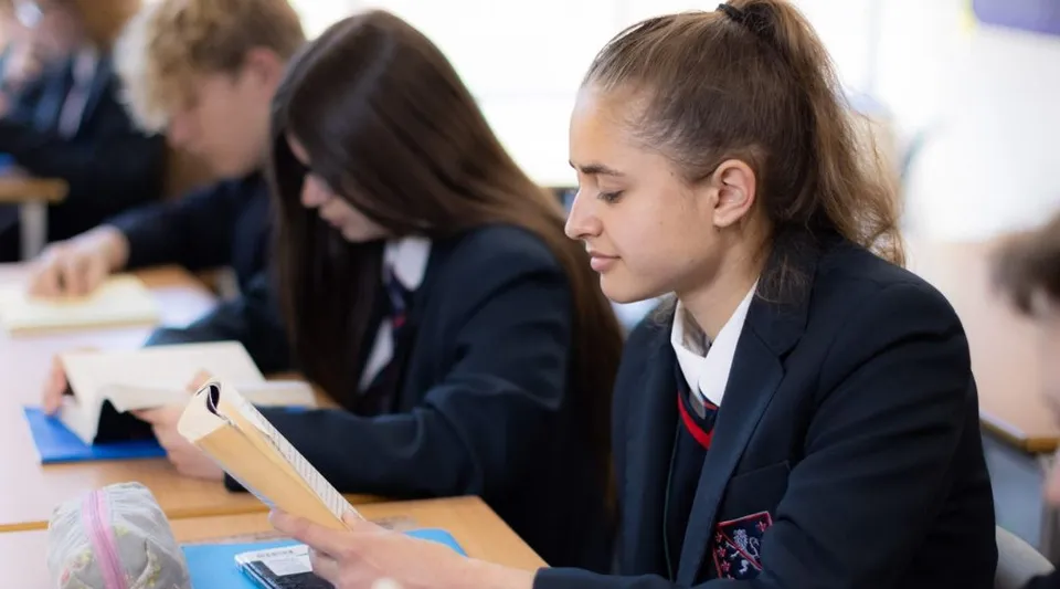 Studenti della Steyning Grammar School and Sixth Form seduti ai banchi in aula mentre lavorano ai loro compiti.