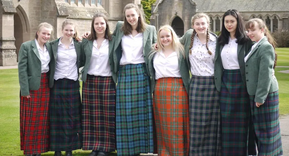 Un gruppo di studentesse in uniforme scolastica si trova davanti a un edificio storico nel campus del Glenalmond College.