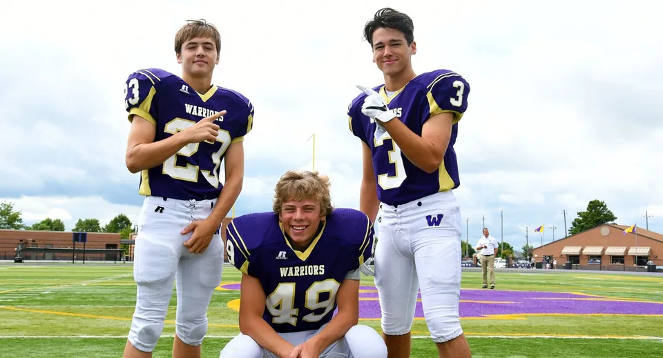 Tre studenti in divisa da football sul campo da gioco della Portland Christian High School.