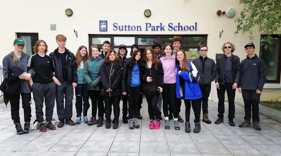 Un gruppo di studenti e studentesse sta davanti all'edificio della Sutton Park School a Dublin.