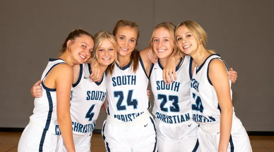 Cinque studentesse della South Christian High School posano con le maglie da basket in una palestra.