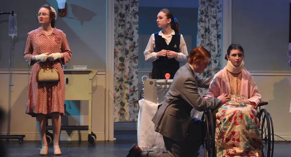 Quattro studenti della Camden Hills Regional High School recitano una scena teatrale in costumi d'epoca in una stanza con tende floreali.