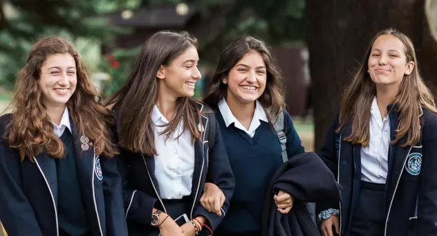 Cuatro alumnas con uniforme escolar en el recinto de un colegio en Inglaterra
