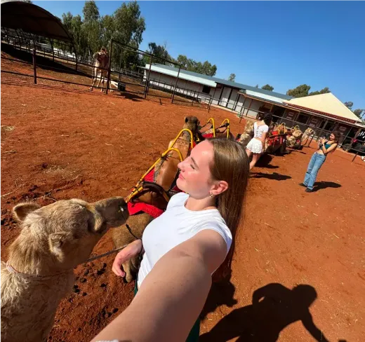Alicia macht ein Selfie neben Kamelen auf einer Farm im australischen Hinterland