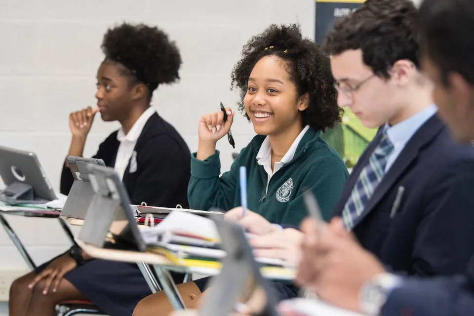 Studenti della Northwest Catholic High School lavorano insieme a un progetto scolastico con i laptop in classe.