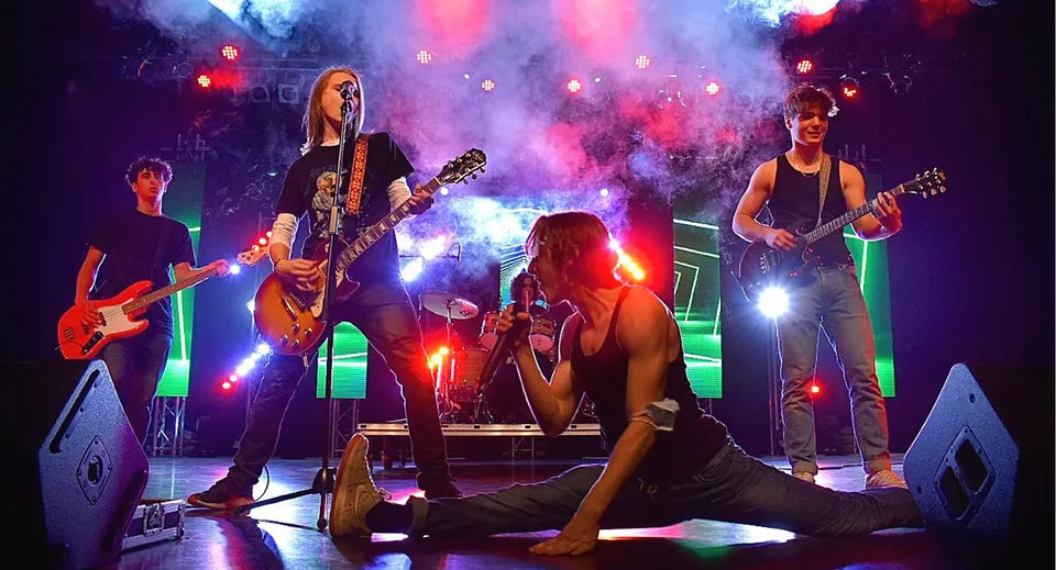 Studenti della Heritage Regional High School suonano come una vivace rock band con luci di scena dinamiche e fumo.