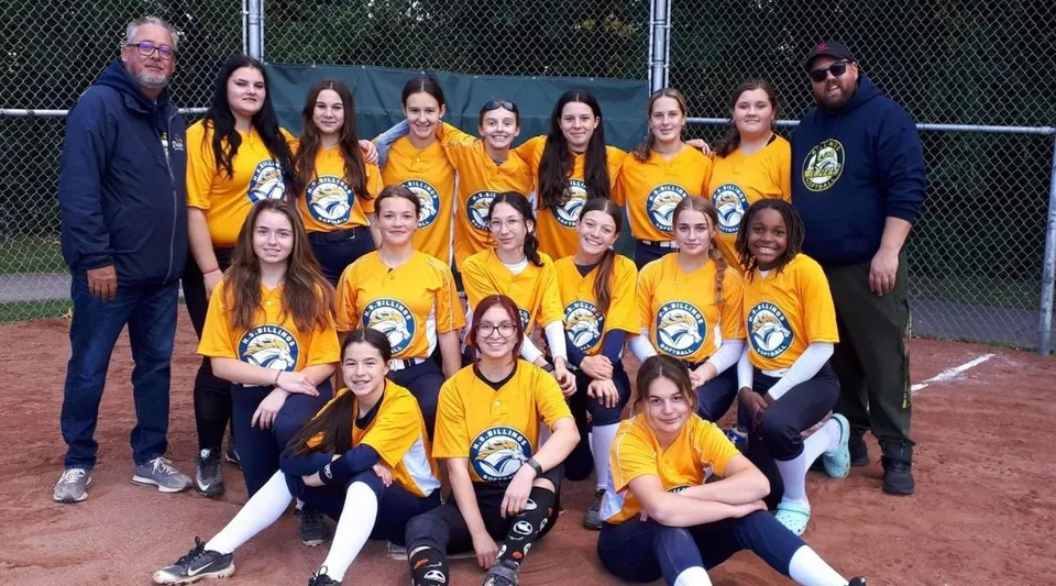 Un gruppo di studentesse della Howard S. Billings High School posa insieme sul campo da baseball.