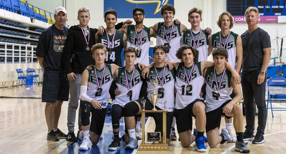 Studenti della Earl Marriott Secondary School posano in abbigliamento sportivo con un trofeo vinto nella palestra.