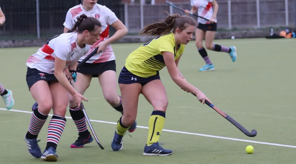 Un gruppo di giovani donne gioca a hockey su prato sul campo sportivo della Kirkham Grammar School.