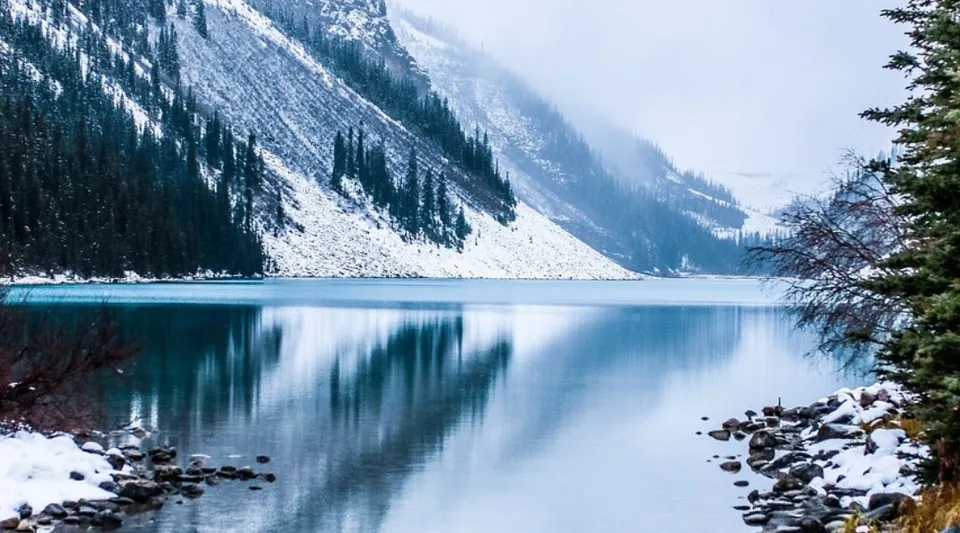 Montagne innevate si specchiano in un lago calmo dall'acqua turchese nel campus del College Bourget.
