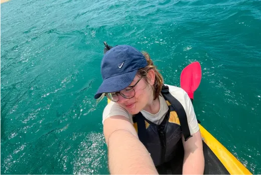 Carla paddelt im Kajak über türkises Wasser in Neuseeland
