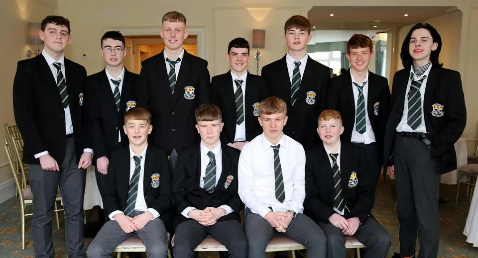 Un gruppo di studenti in divisa scolastica posa insieme nel campus del Newbridge College.