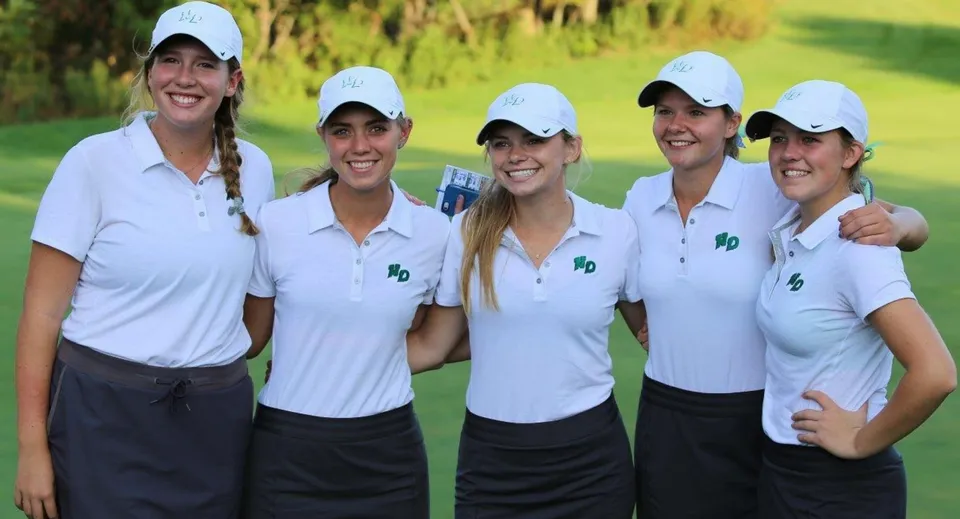 Un gruppo di cinque studentesse in polo da golf bianche si trova su un prato nel campus della Notre Dame de la Baie Academy.
