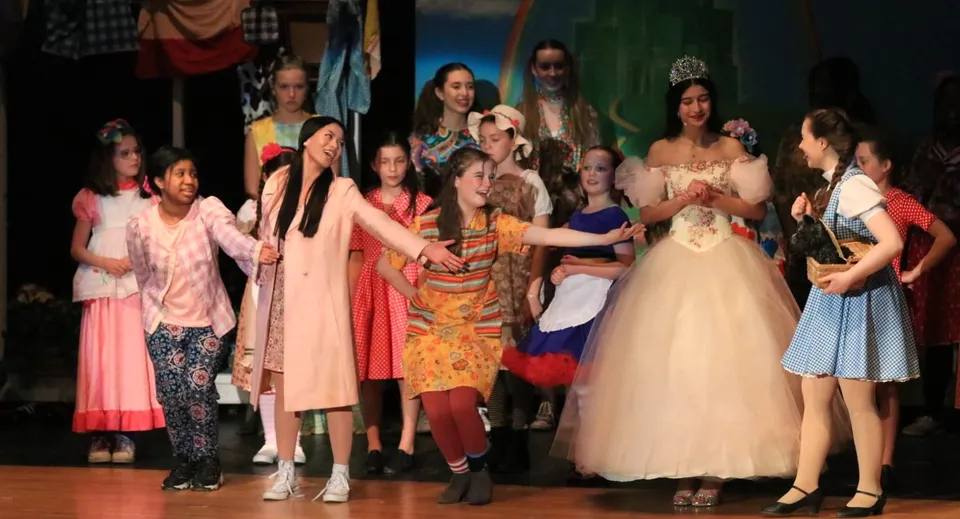 Un gruppo di studentesse in abiti colorati mette in scena una performance sul palco della St. Mother Teresa High School.