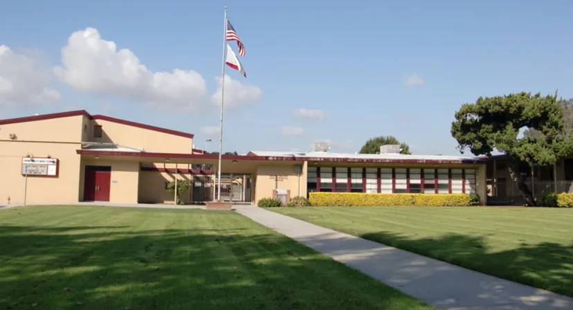 Un edificio a un piano con tetto rosso e bandiera americana nel campus del Chino Valley Unified School District.