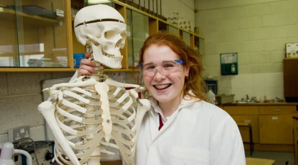 Una studentessa della Loreto Secondary School a Cork si trova accanto a un modello di scheletro in classe.