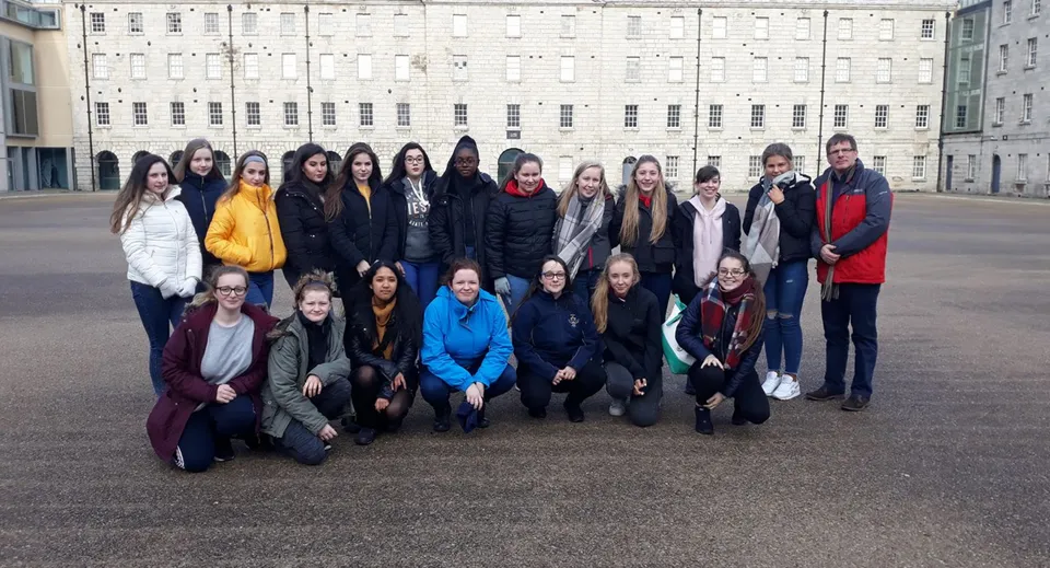 Un gruppo di studentesse si trova davanti al grande edificio bianco dell'Our Lady's College.
