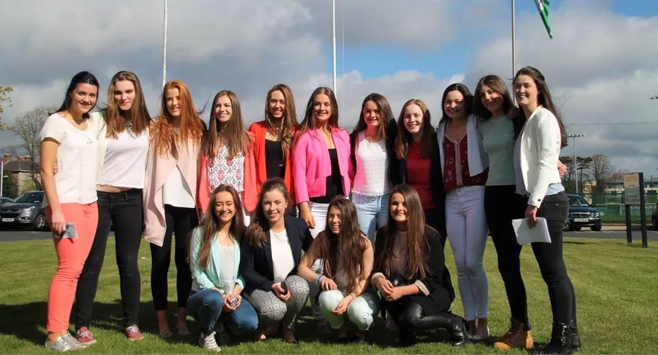 Un gruppo di studentesse si trova su un prato nell'area esterna dell'Alexandra College sotto un cielo nuvoloso.