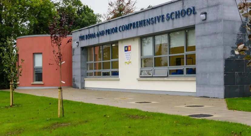 L'edificio scolastico moderno a più piani della Royal and Prior Comprehensive School con ampie finestre e un'area verde antistante.