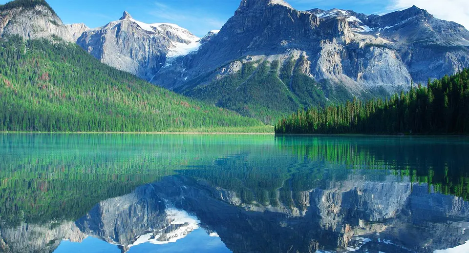 Un lago di montagna turchese in Columbia Britannica vicino alla Vancouver Technical Secondary School che riflette le montagne.