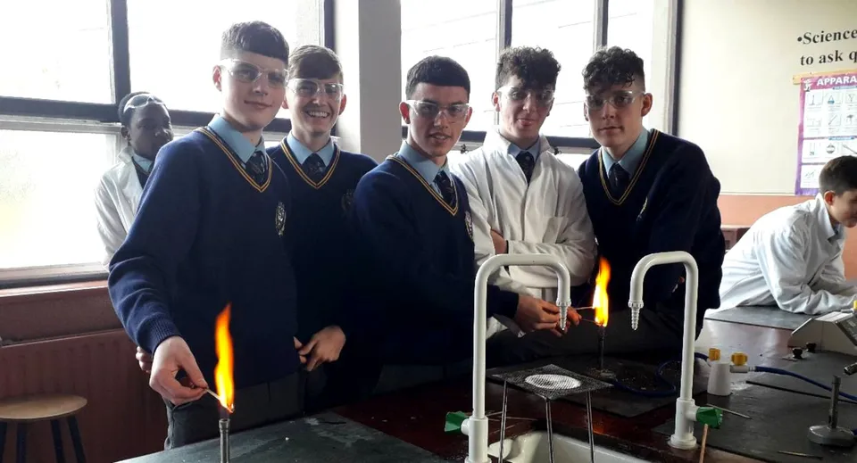 Un gruppo di studenti in divisa scolastica si trova insieme nell'edificio scolastico del Franciscan College Gormanston.