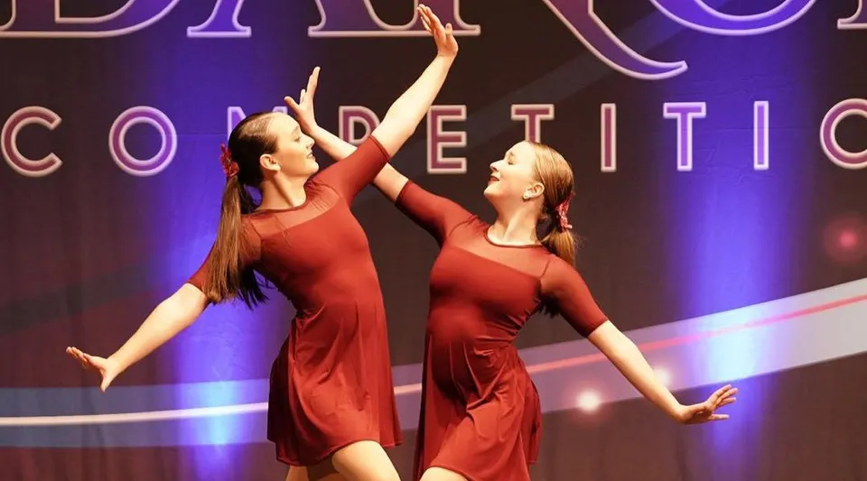 Due ballerine in abiti rossi si esibiscono durante una competizione di danza sul palco della Marianapolis Preparatory School.