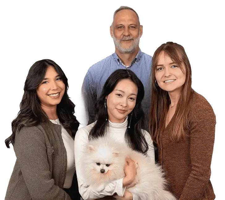 Team di consulenti sorridenti in posa, uno tiene in braccio un piccolo cane bianco