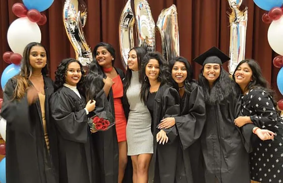 Un gruppo di ragazze in toga da diploma in posa durante la cerimonia di diploma all'Albert Campbell Collegiate Institute.
