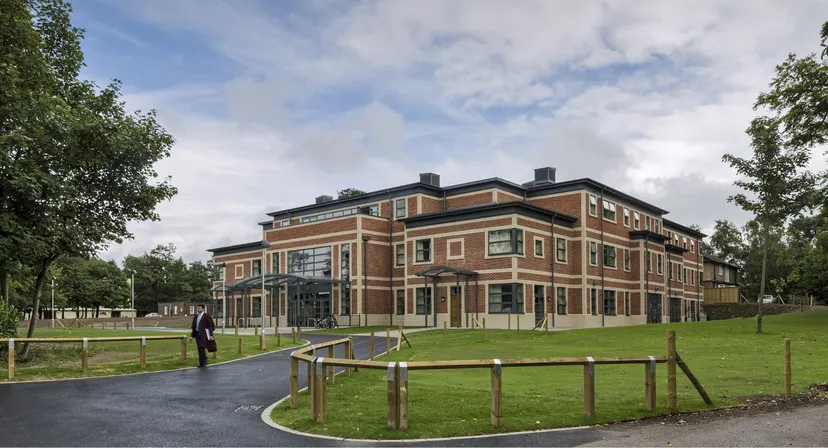 L'edificio in mattoni rossi della Royal Russell School con un viale asfaltato e prati verdi antistanti.