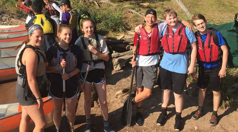 Un gruppo di studenti della University Lake School in abbigliamento da trekking si trova su un sentiero immerso nella natura.
