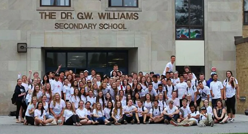 Un grande gruppo di studenti posa davanti all'ingresso della Dr. G.W. Williams Secondary School.