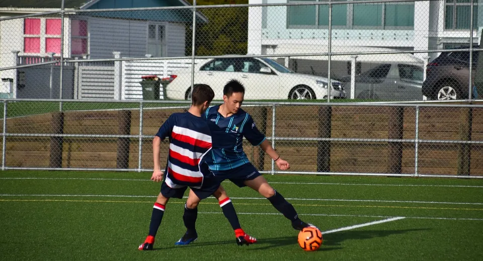 Due giocatori di calcio in divisa giocano una partita sul campo da gioco dell'ACG Parnell College.