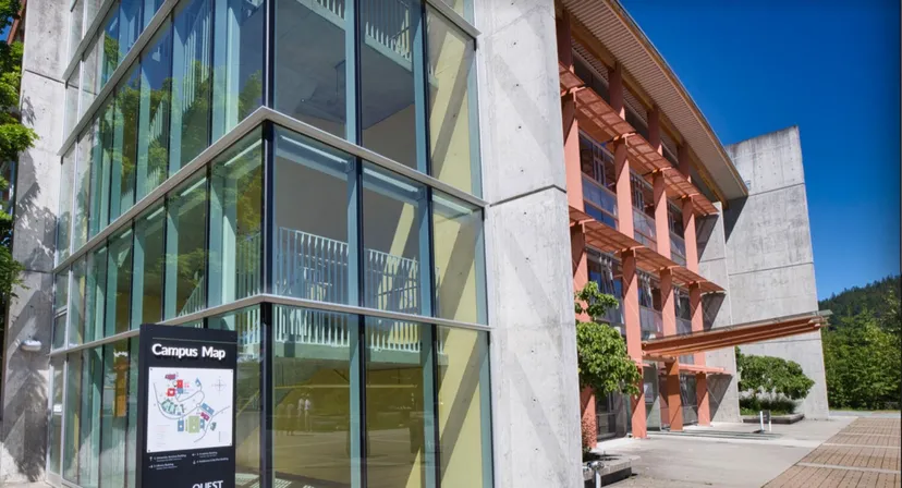 L'edificio moderno della Phoenix Magnet Academy con un cartello della mappa del campus sotto un cielo limpido.