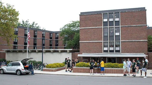 Schüler stehen vor dem Backsteingebäude der Indiana Academy for Science, Mathematics and Humanities.