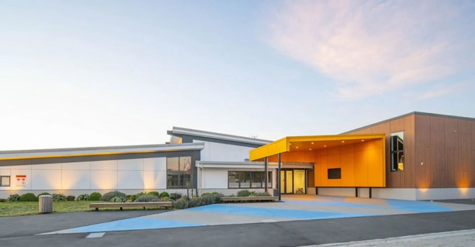 L'edificio moderno e colorato della Kaiapoi High School si staglia contro un cielo terso ed è circondato da percorsi e vegetazione.