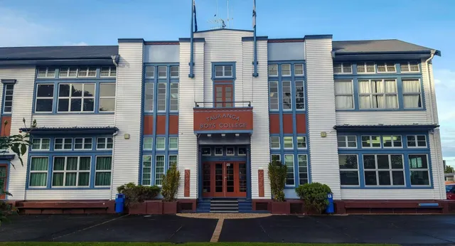 Das mehrstöckige Gebäude mit Art-Deco-Fassade des Tauranga Boy's College ist von gepflastertem Bereich und Grünflächen umgeben.