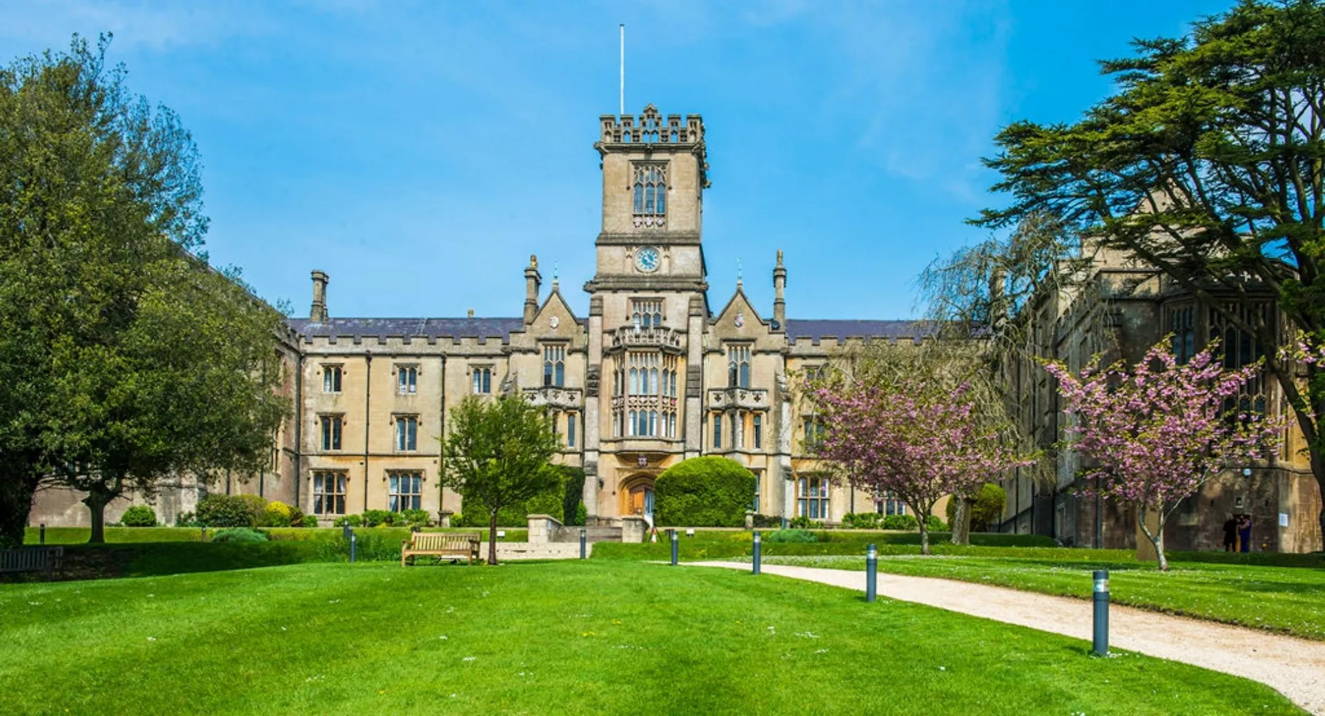 L'edificio principale storico della Kingswood School con una torre centrale, circondato da un prato e alberi.