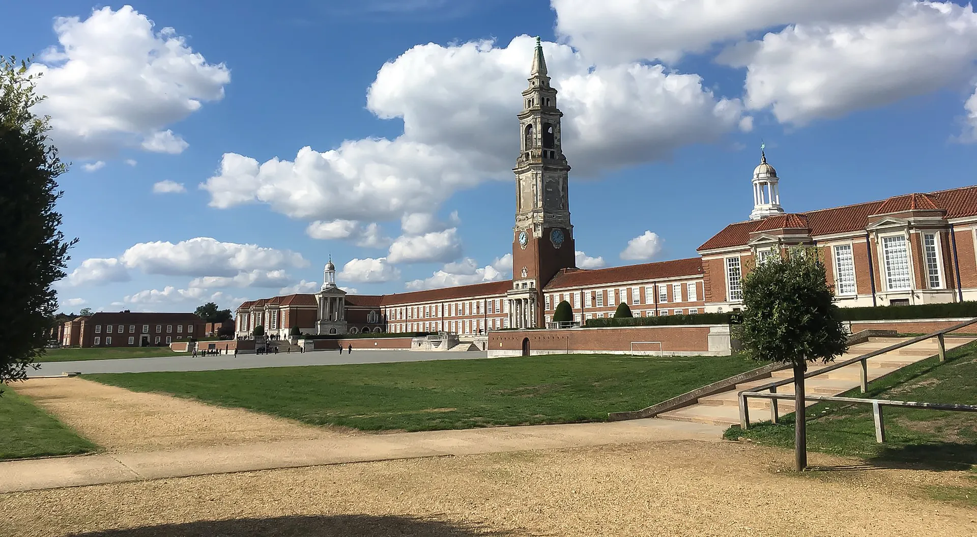 L'ampio edificio con un'alta torre si trova nel campus della Royal Hospital School, davanti a un prato con un viale in ghiaia.