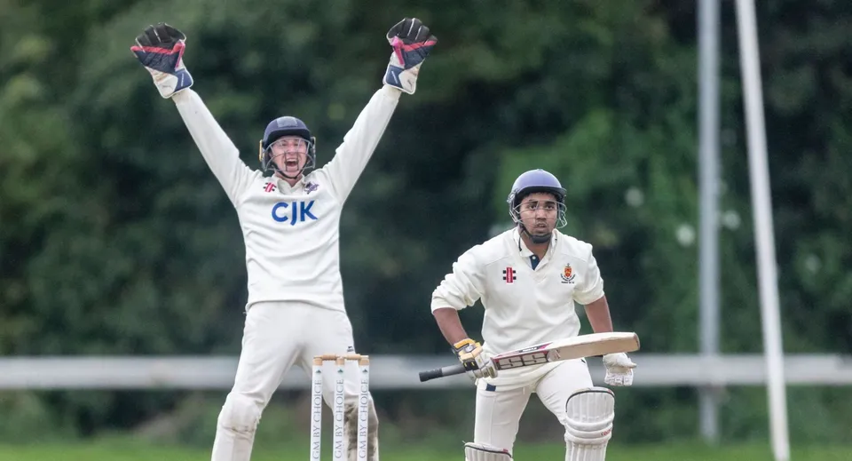 Due giocatori di cricket sul campo della Sutton Park School, uno esulta a braccia alzate, l'altro tiene una mazza.