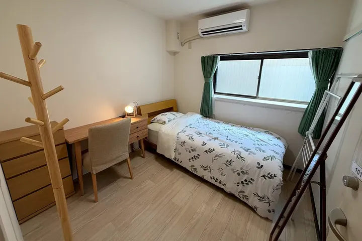 Traditionelles japanisches Zimmer mit Tatami-Matten und rundem Fenster ins Grüne
