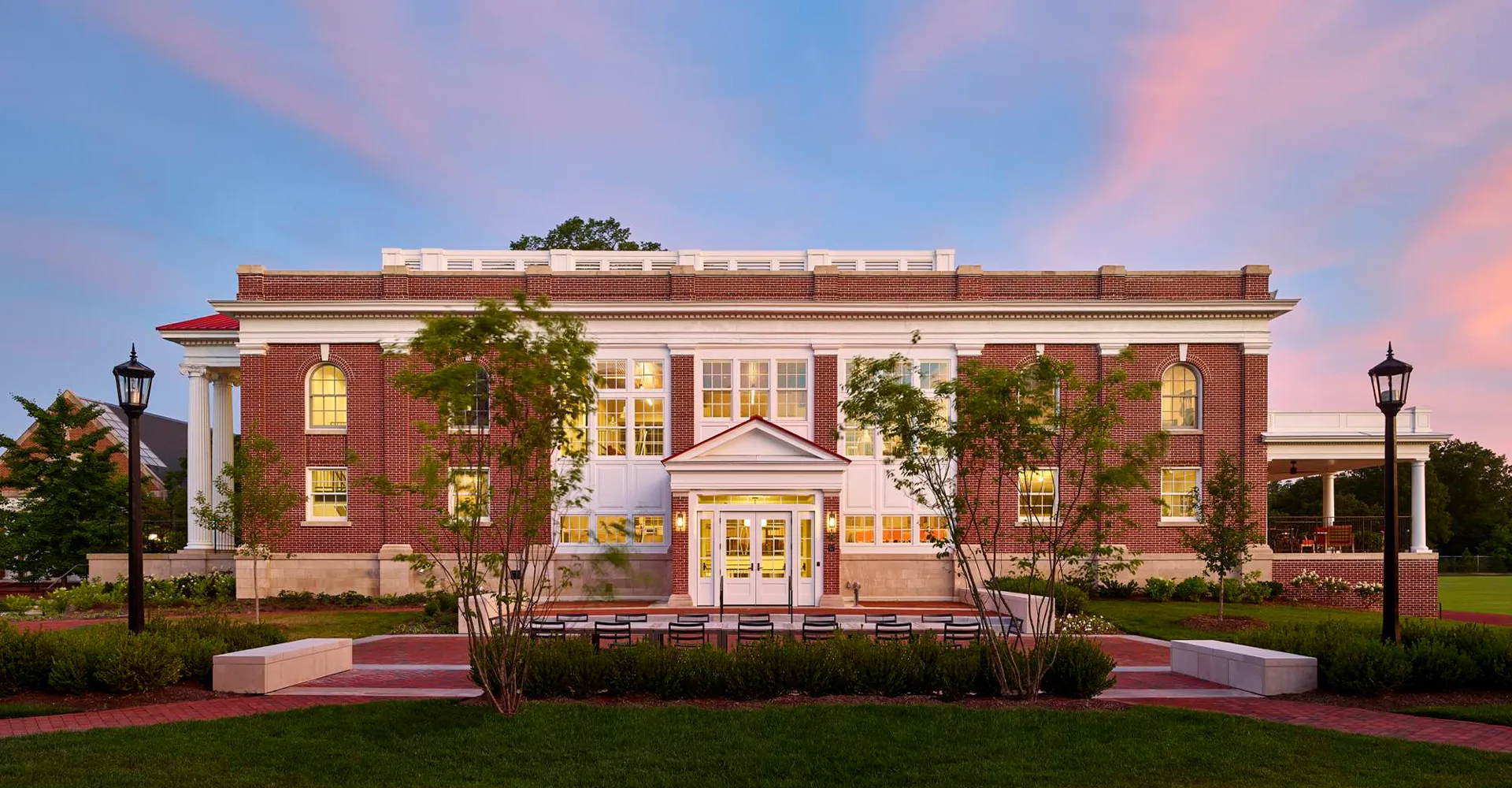 L'edificio in mattoni con ingresso a colonne si trova nel campus della Episcopal High School ed è circondato da alberi verdi.