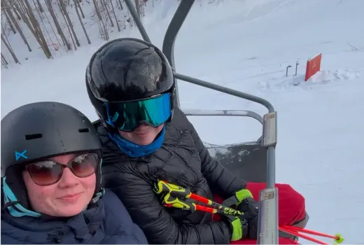 Zwei Mädchen auf einem Sessellift in einem verschneiten Skigebiet in Kanada