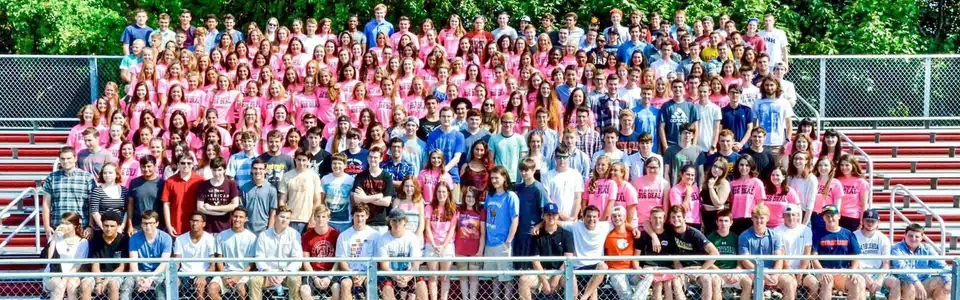 Un gruppo di giovani si trova insieme nel verde all'interno del campus della Marblehead High School.