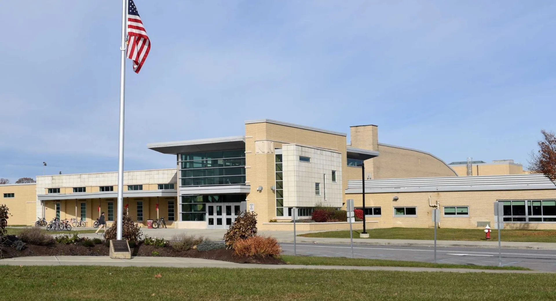 L'edificio moderno a più piani della Niskayuna High School con una grande bandiera americana e un prato ben curato.