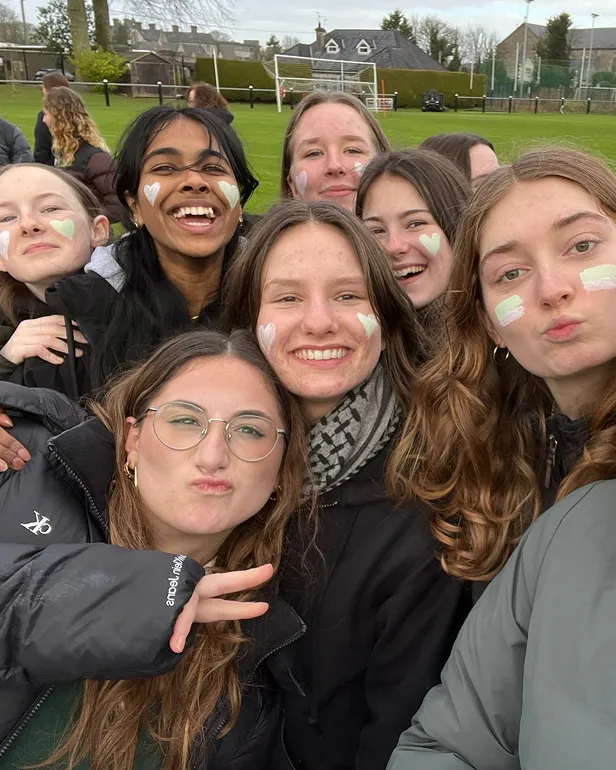 Selfie de un grupo de chicas con la cara pintada en el campo de deportes del colegio