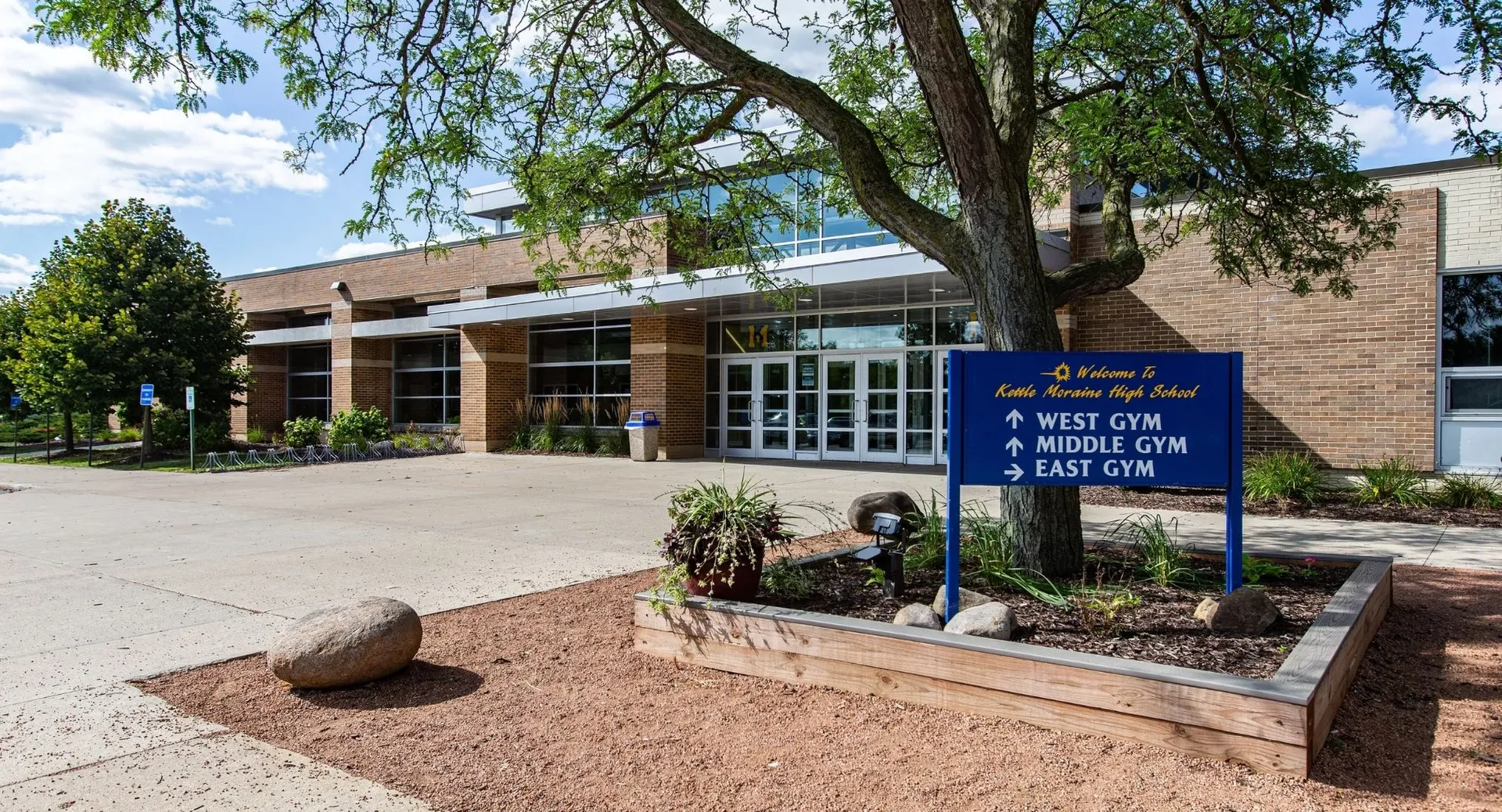 L'edificio in mattoni con cartelli informativi che indicano le diverse palestre nel campus della Kettle Moraine High School.