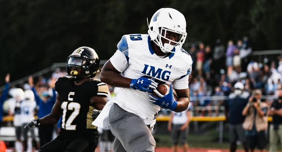 Un giocatore di football americano della IMG Academy corre con il pallone durante una partita.