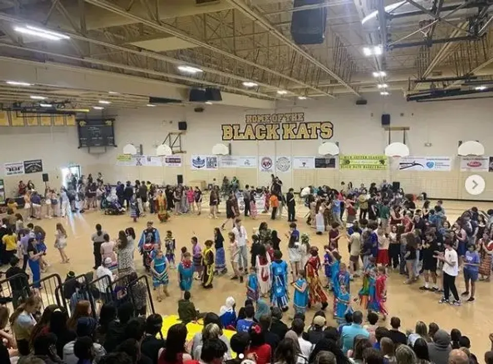 Molti studenti si radunano nella palestra di basket della Fredericton High School davanti all'insegna dei Blackcats.