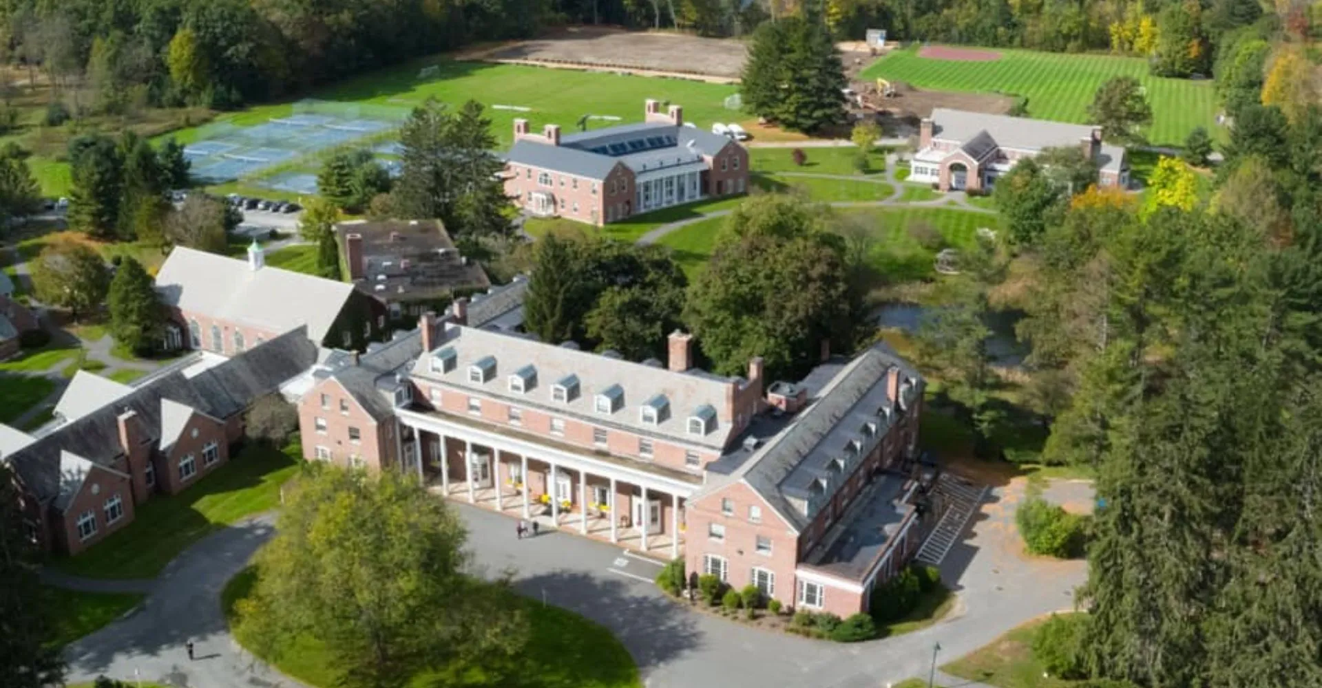 Il grande edificio in mattoni con una torre centrale nel campus della The Marvelwood School è circondato da aree verdi.