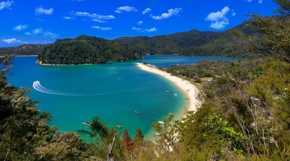 Una spiaggia tropicale con acque turchesi cristalline e colline verdi, fotografata nei dintorni di Hutt Valley High School.